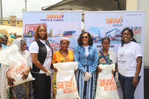 Group Coordinating Director, SIFAX Group, Women Eniola-Jegede with other women Representatives of SIFAX Group handing over essential food items to women in the Ijora community during an outreach programme held on Friday 