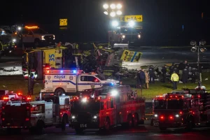 A Port Authority aircraft rescue and firefighting vehicle lays on its side off of runway 4 after colliding with an Air Canada jet after it landed at LaGuardia Airport, New York, on March 23, 2026. Ryan Murphy/AP